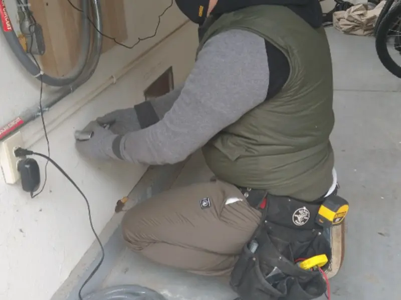 Electrician performing outlet wiring in a Barton garage